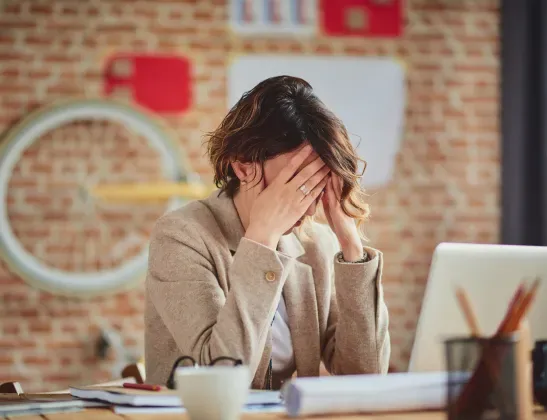 woman-working-hiding-her-face-in-her-hands